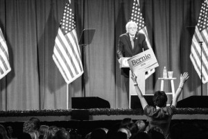 A supporter stands up with a sign during Sen. Bernie Sanders' speech. Photo by Anna Sortino. 